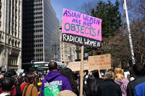 a man carries a sign that says asian women are not objects at a stop asian hate protest in nyc