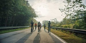 asian chinese cyclist team cycling in rural area during weekend morning backlit warm light