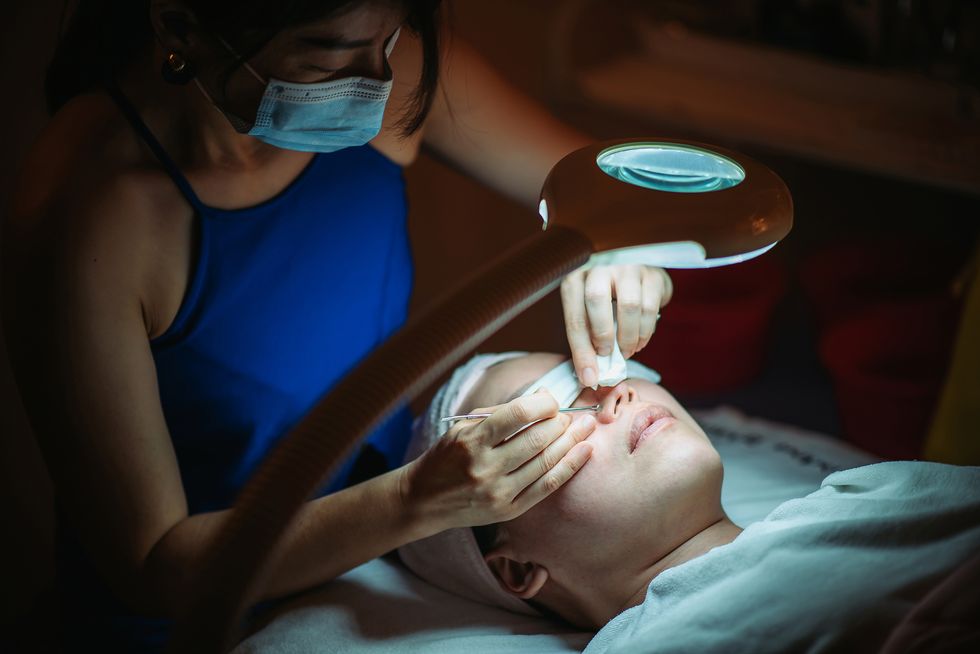 asian chinese female receiving acne face treatment at facial beauty salon