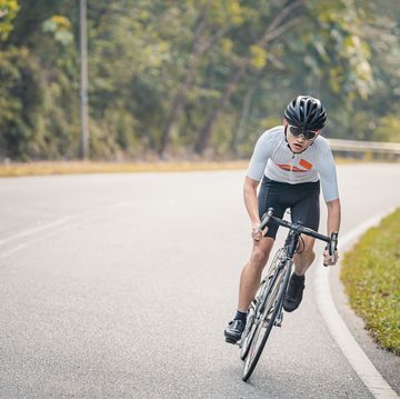 asian chinese professional cyclist athlete sportsman sprinting cycling in rural area