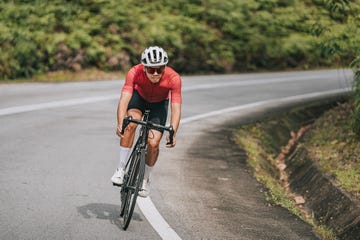 asian chinese professional cyclist athlete sportsman sprinting cycling in rural area