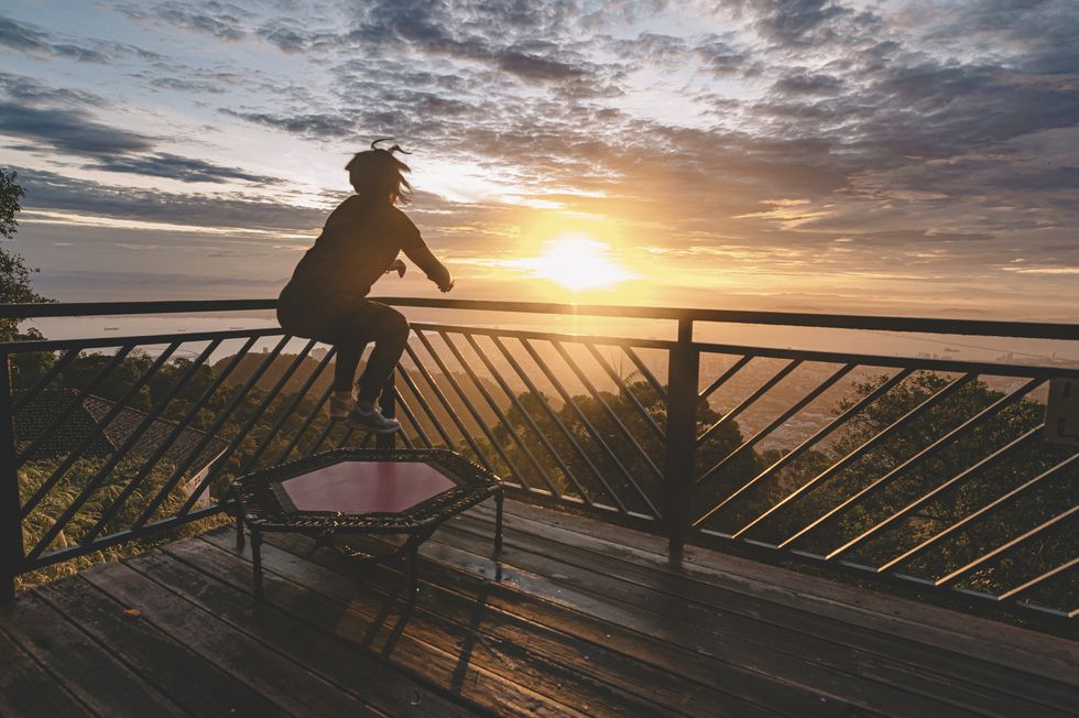 asian chinese sport athlete mini trampoline workout in penang hill in the first light of morning