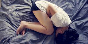 asian female feel hurt and pain on period on the bed