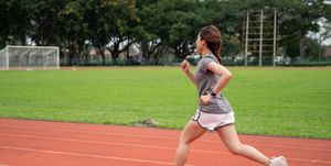 asian female runner doing her workout by sprinting in placa running track