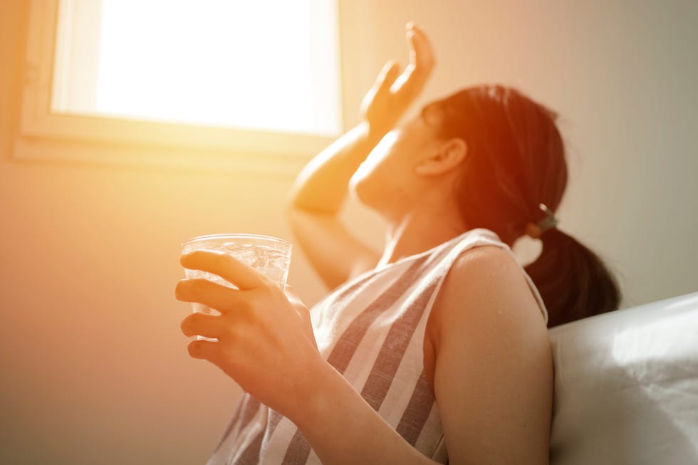 asian female thirsty and dehydration drinking fresh water at summer season at home