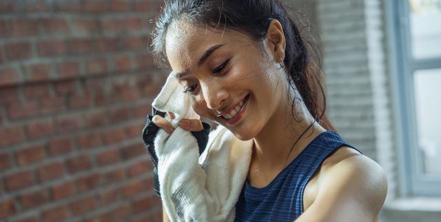 Asian girl exercising in gym she tired and She has sweat on her face.