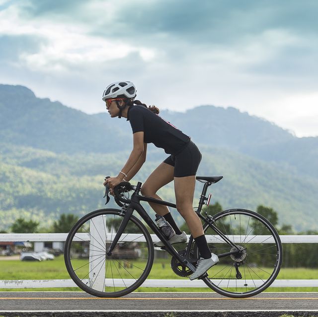 Asian healthy Cyclist girl wearing helmet Cycling and exercise on bicycle in sprint track and open road
