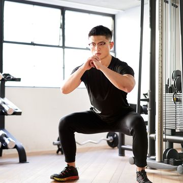 asian man squatting in a training gym