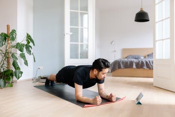 Asian man uses digital tablet to lean plank position