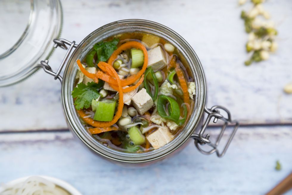 asian rice noodle soup with vegetables and tofu in jar
