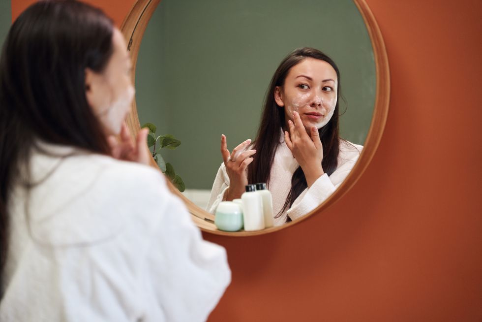 asian woman applying moisture cream at her face