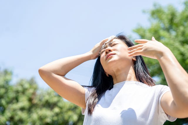 asian woman drying sweat with a cloth in a warm summer day