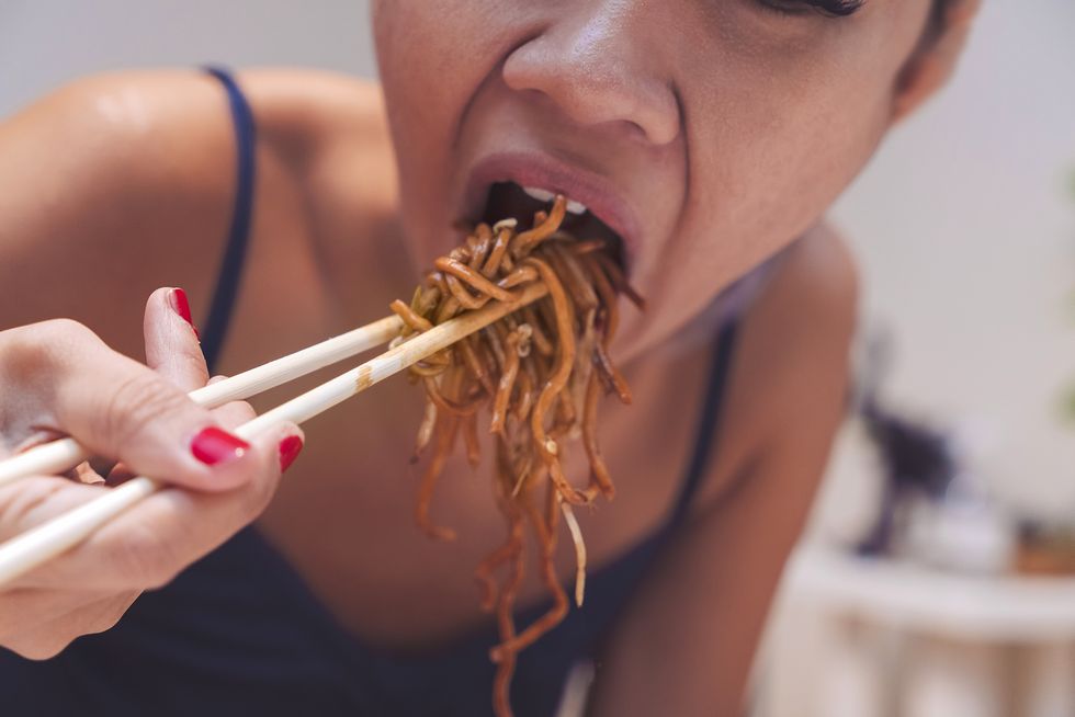 asian woman eating noddle by chopsticks    close up
