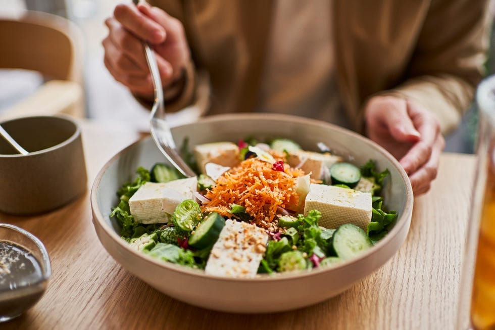 a healthy salad featuring tofu cucumbers and grated carrots