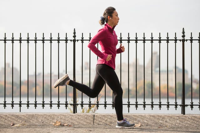 Asian woman running on waterfront path