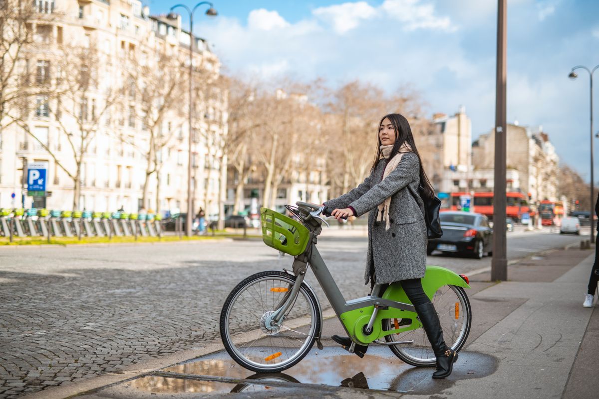 asian woman using ebicycle in the city
