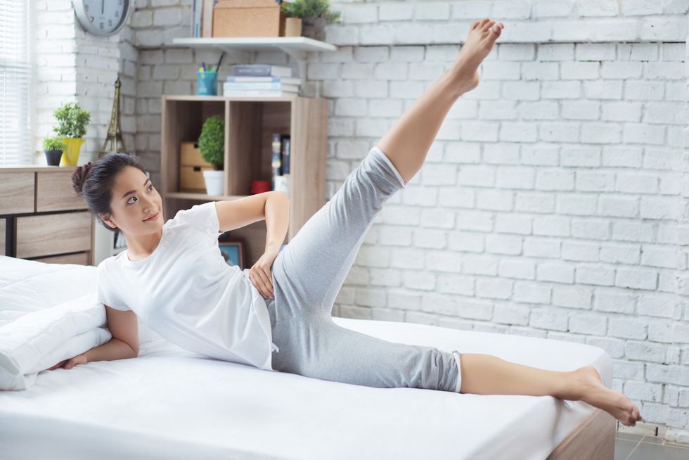 asian women exercising in bed in the morning, she feels refreshedshe acts as squat