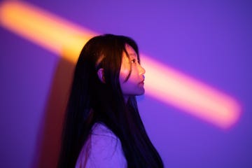 young woman standing under spotlight at night