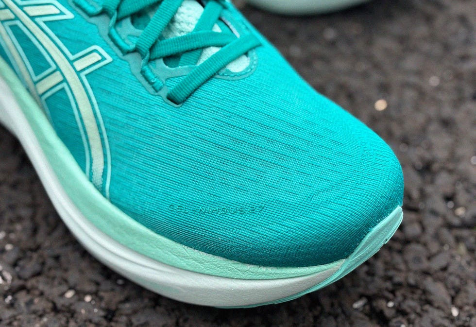 running shoe featuring a turquoise upper with distinct textured patterns and branding