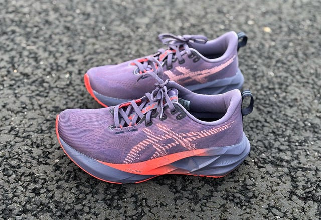 purple asics novablast 5 running shoe on tarmac road
