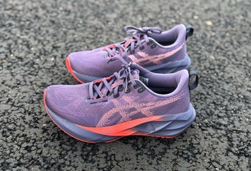 purple asics novablast 5 running shoe on tarmac road