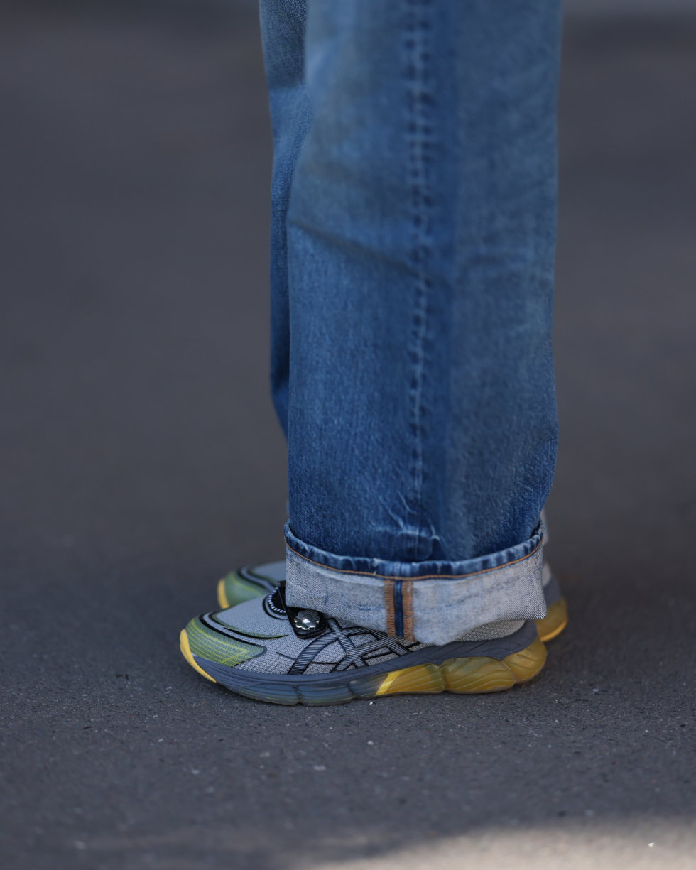 athletic shoes worn with rolledup denim jeans