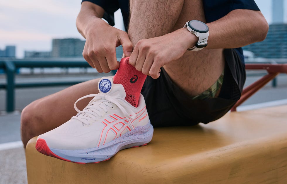 a person lacing up a white running shoe