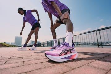 two athletes stretching in athletic wear on a sunny outdoor track