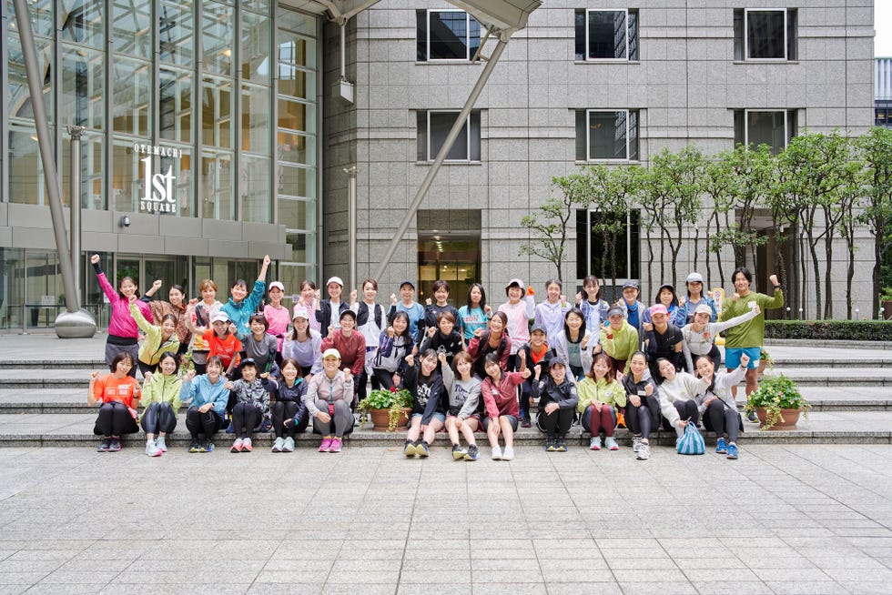 a group of people posing for a photo in front of a building