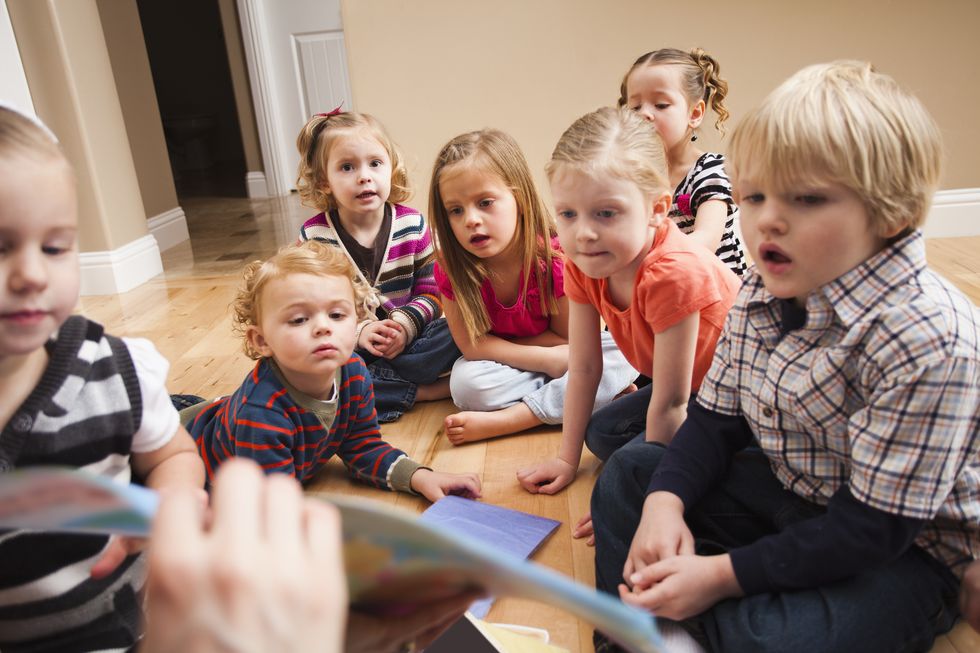 Children (2-3, 4-5) sitting on floor and learning