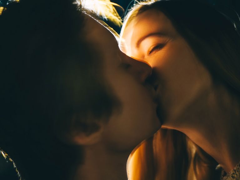 young couple in love in dark with back lit close up