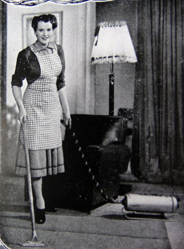 Giovane donna che passa l'aspirapolvere sul tappeto di casa ai generativa