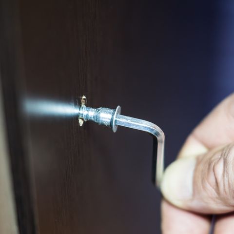 Assembling of furniture, closeup hex wrench in man hand