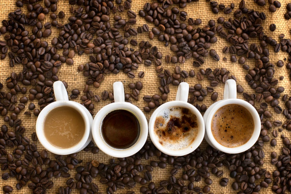 assorted coffee drinks in cups on coffee beans background