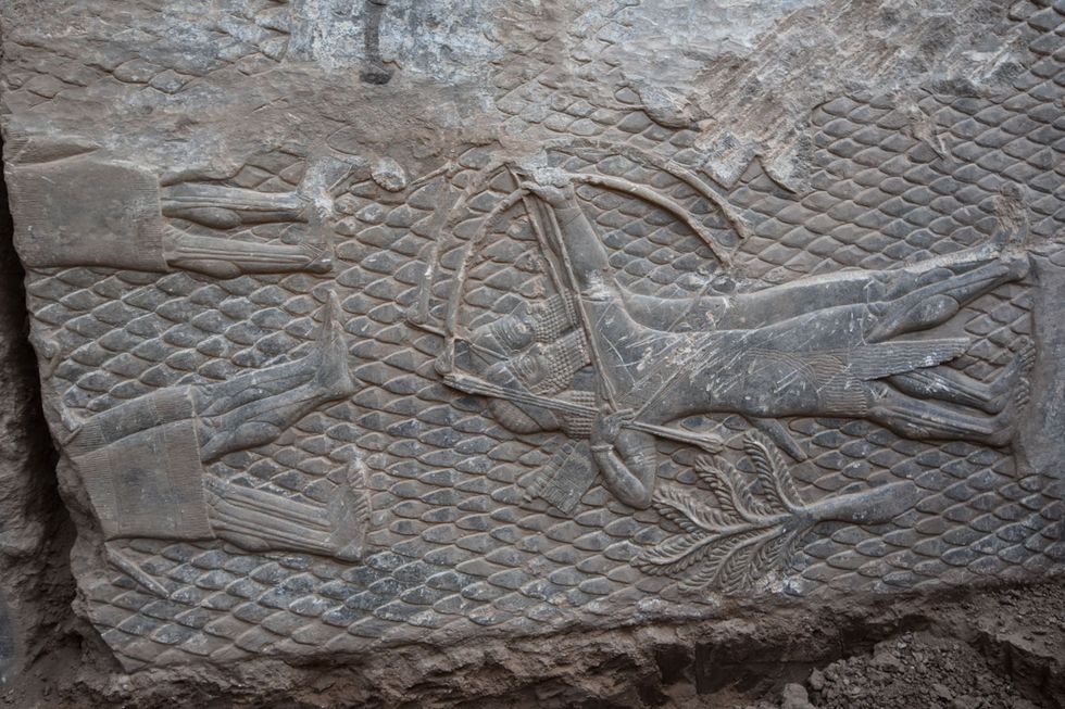 Op een op zijn kant ingegraven plaat staan Assyrische boogschutters afgebeeld Het kegelvormige patroon op de achtergrond duidt erop dat ze in een heuvelachtige of bergachtige omgeving staan