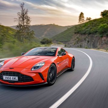 a red 2025 aston martin vantager driving on a road