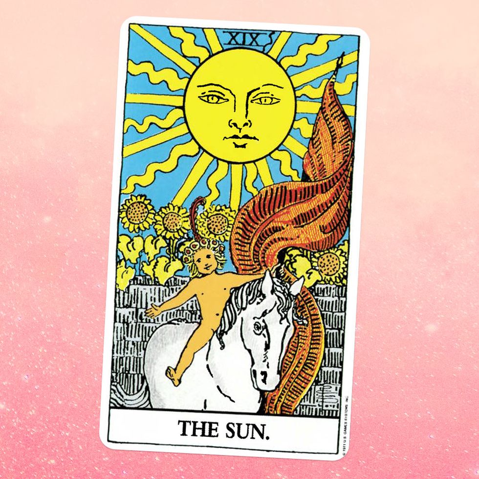 the tarot card for the sun, showing a nude androgynous young child with blonde hair sitting on a white horse, with a giant sun and a field of sunflowers behind gthem