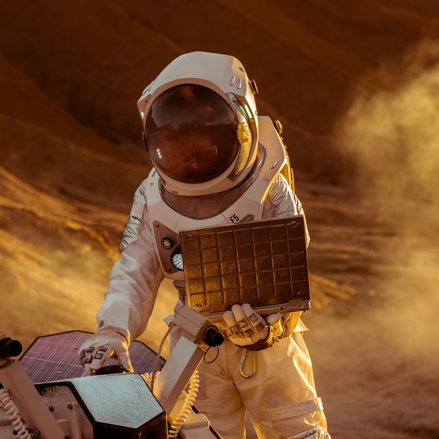 astronaut in the space suit works on laptop, adjusting rover for mars further mars explorationspace exploration conceptfirst manned mission on red planet