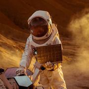 astronaut in the space suit works on laptop, adjusting rover for mars further mars explorationspace exploration conceptfirst manned mission on red planet
