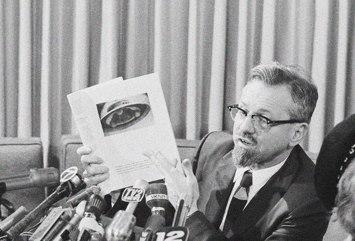 https://hips.hearstapps.com/hmg-prod/images/astrophysicist-dr-h-allen-hynek-holds-a-photograph-of-a-news-photo-1576101742-1-noice-1576162722.jpg?crop=0.668xw:0.983xh;0.204xw,0.00240xh&resize=1200:*