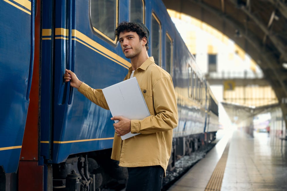 man carrying a laptop onto a train