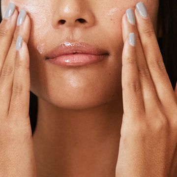woman applying skincare product to face