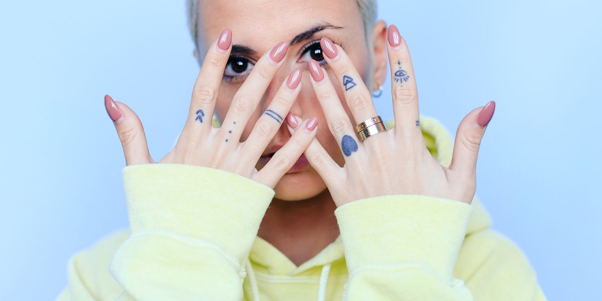 woman with tattooed hands showing off manicure