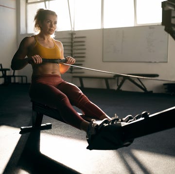 at the gym, strong caucasian woman exercising on the rowing machine