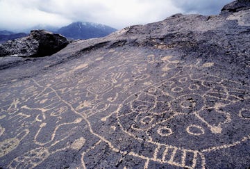 petroglyphs of paiute or shoshone origin near the owens valley in the eastern sierra, carved into volcanic tuff by chipping away the dark, top layer and exposing a light surface below