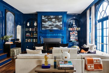 a living room with a fireplace mantel painted a rich blue with an abstract artwork in a similar color palette hanging above