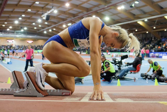 una atleta rubia se prepara en los tacos de salida para correr los 400 metros del world indoor tour de atletismo de madrid en 2020