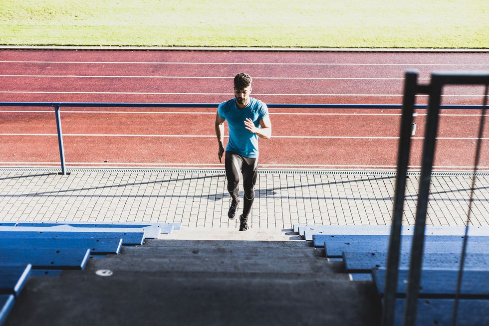 athlete exercising on grandstand of a track and field stadium