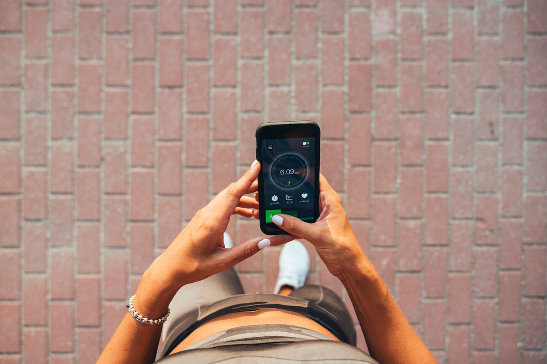 athlete looking on smartphone with training data on display