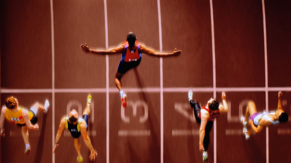 atleta su pista di atletica che corre arrivando primo